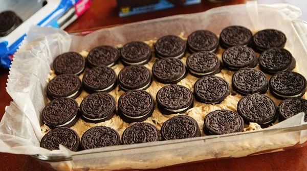 La pâte à cookie est ensuite déposée dans le moule préparé et lissée pour